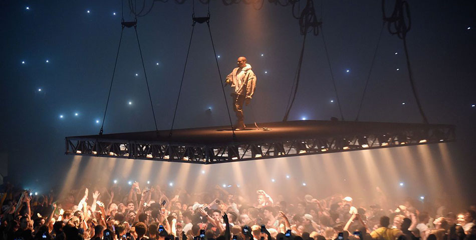 Un fan se cuelga del escenario de Kanye West